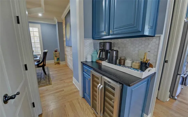 a open kitchen with stainless steel appliances granite countertop a stove refrigerator a dining table and chairs with wooden floor