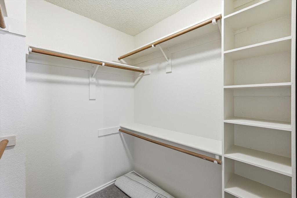 318 Lodge Road Coppell, TX 75019 - Photo 25 of 35 The roomy walk-in closet offers multiple hanging areas, built-in shelving and plenty of space for organized storage.