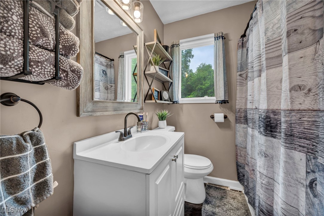1661 Keefer Road Girard, OH 44420 - Photo 17 of 35 Main Floor Bathroom featuring vanity, toilet, baseboards, and a shower with curtain