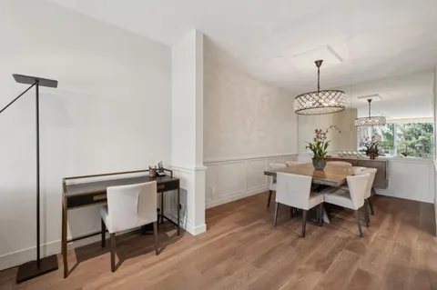 a view of a dining room with furniture wooden floor and chandelier