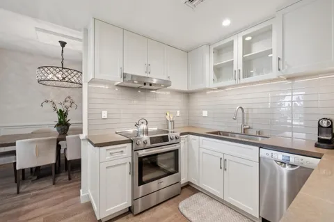 a kitchen with stainless steel appliances a sink a stove and cabinets