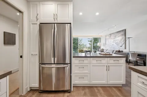 a kitchen with white cabinets and stainless steel appliances