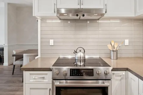 a stove top oven sitting inside of a kitchen