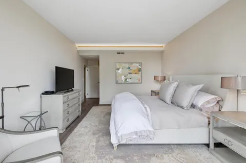 a spacious bedroom with a bed and a flat screen tv