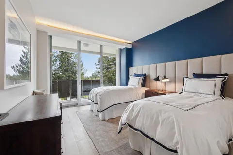 a bedroom with two beds and a large window