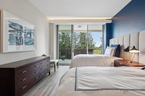 a large bed sitting in a bedroom next to a window