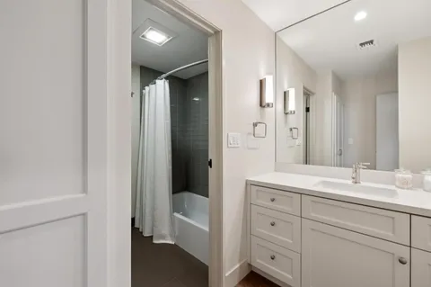 a spacious bathroom with a double vanity sink a mirror and a bathtub