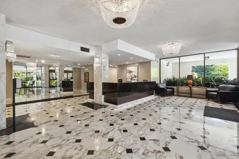 a large kitchen with a chandelier and living room view