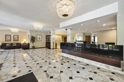 a living room with furniture floor to ceiling window and a flat screen tv