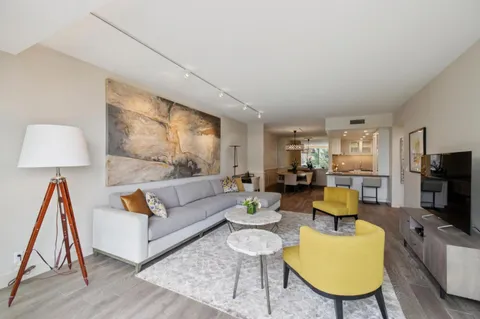 a living room with furniture a flat screen tv and a lamp