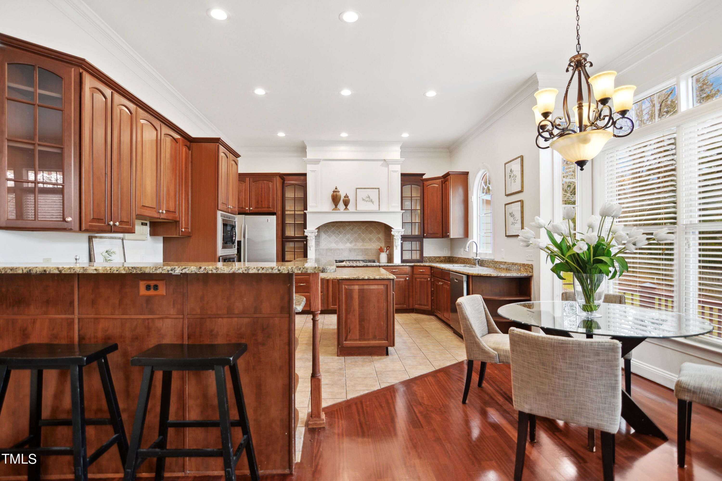3101 Shinleaf Court Raleigh, NC 27613 - Photo 12 of 44 a kitchen with granite countertop white cabinets stainless steel appliances and chairs