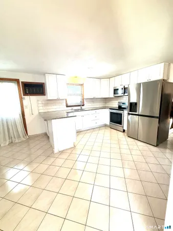 a large white kitchen with a stove a sink and a refrigerator