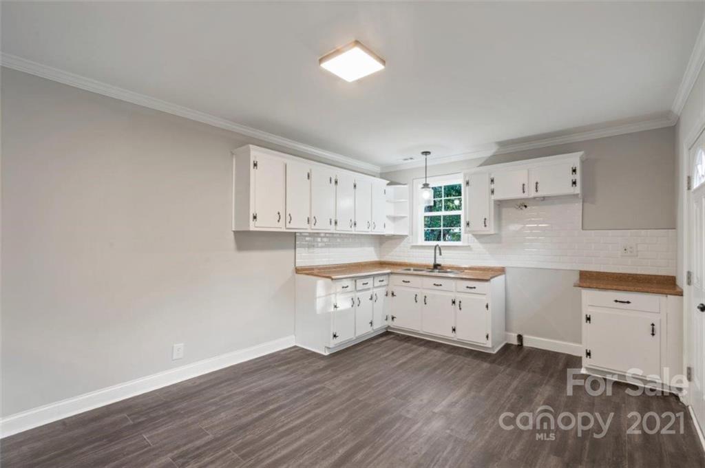 235 Porter Road Rock Hill, SC 29730 - Photo 14 of 29 a kitchen with wooden floors and white cabinets