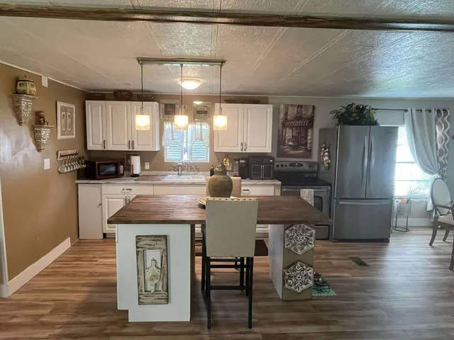 a kitchen with stainless steel appliances granite countertop a stove refrigerator sink and cabinets