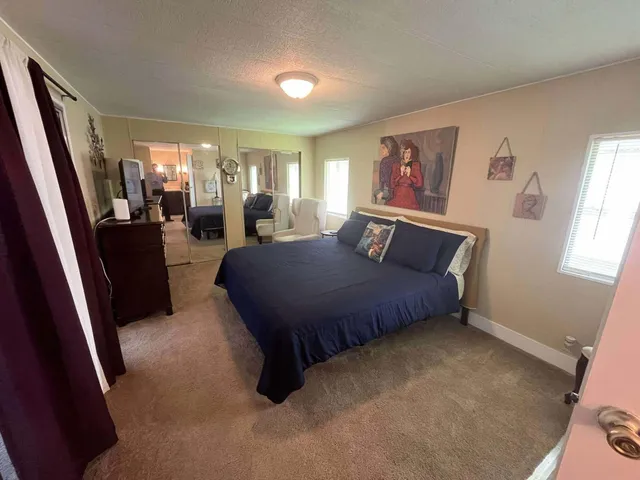 a spacious bedroom with a bed and glass window