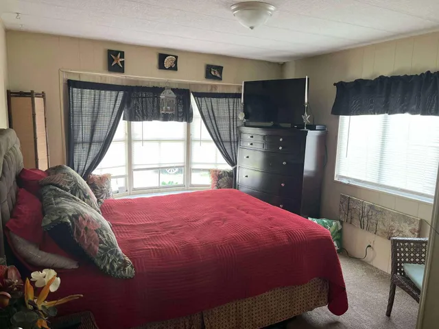 a bed sitting in a bedroom next to a window