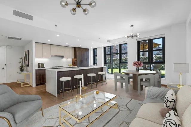 a living room with furniture a table and kitchen view