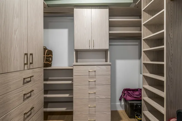 a view of walk in closet with empty racks