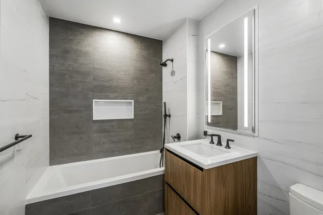 a bedroom with a bed a mirror and a large window