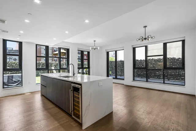 a view of kitchen with stainless steel appliances kitchen island wooden floor and window