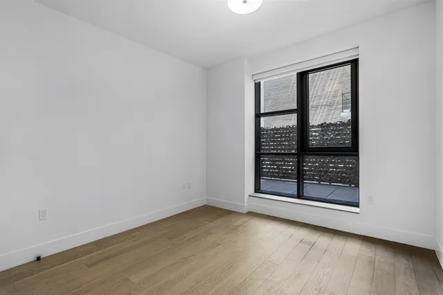 a view of a hallway with wooden floor and a shower