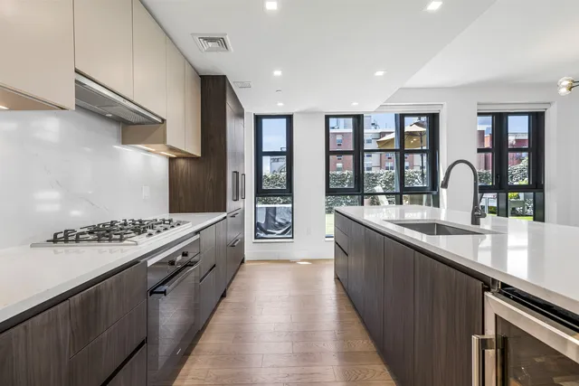 a large living room with stainless steel appliances granite countertop a stove and a large window