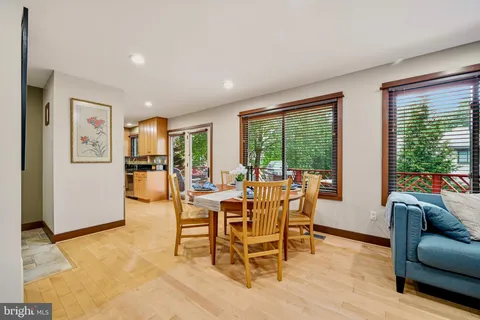 a view of a dining room with furniture a fireplace and wooden floor