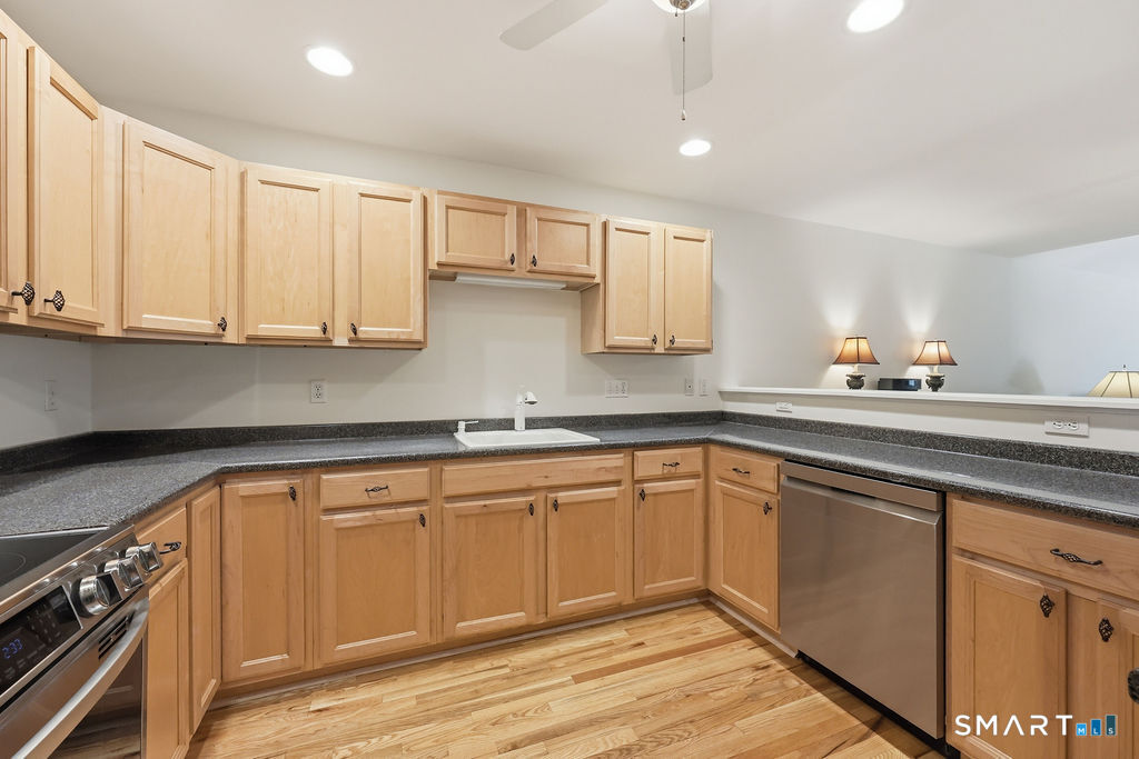 98 Haley Lane, Unit 98 Newtown, CT 06482 - Photo 12 of 33 a kitchen with granite countertop white cabinets sink and stainless steel appliances