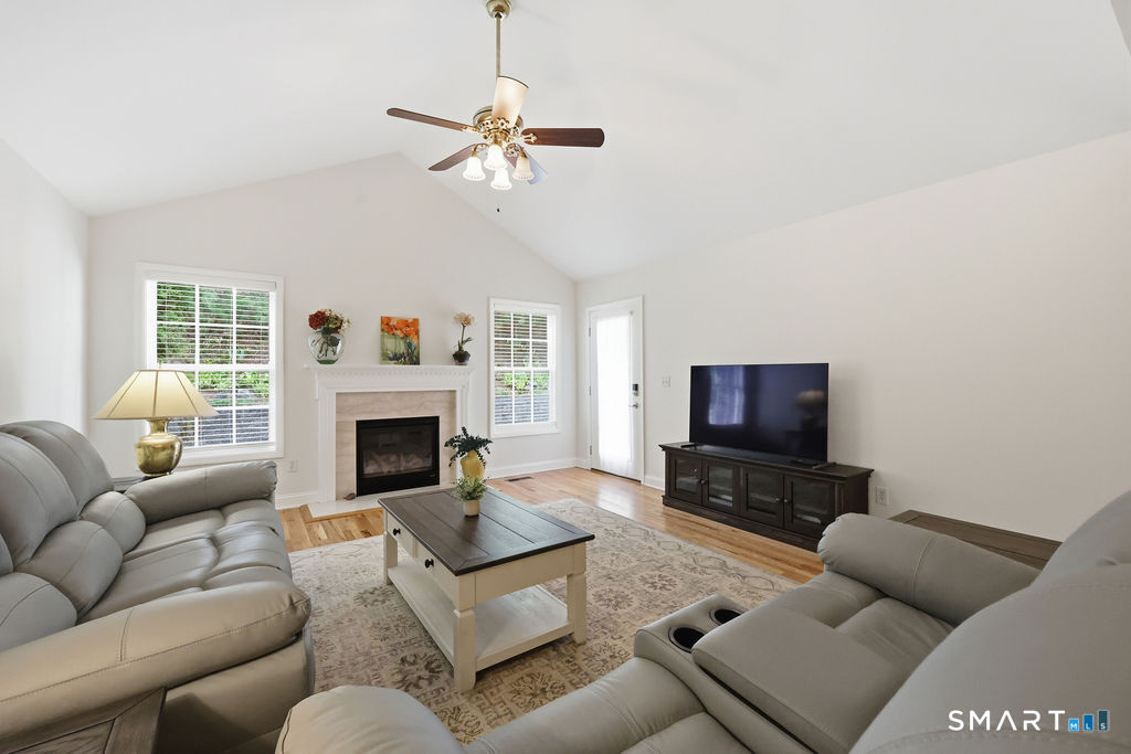 98 Haley Lane, Unit 98 Newtown, CT 06482 - Photo 21 of 33 a living room with furniture a fireplace and a flat screen tv