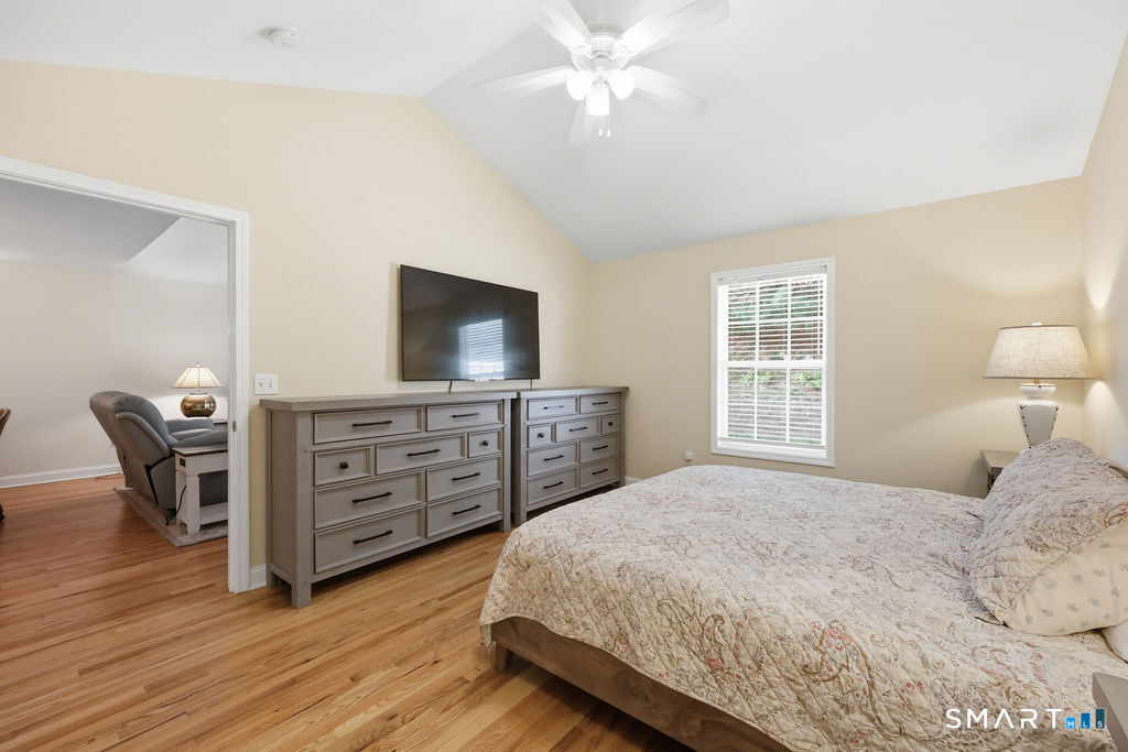 98 Haley Lane, Unit 98 Newtown, CT 06482 - Photo 24 of 33 a bedroom with a bed and a flat tv screen on dresser