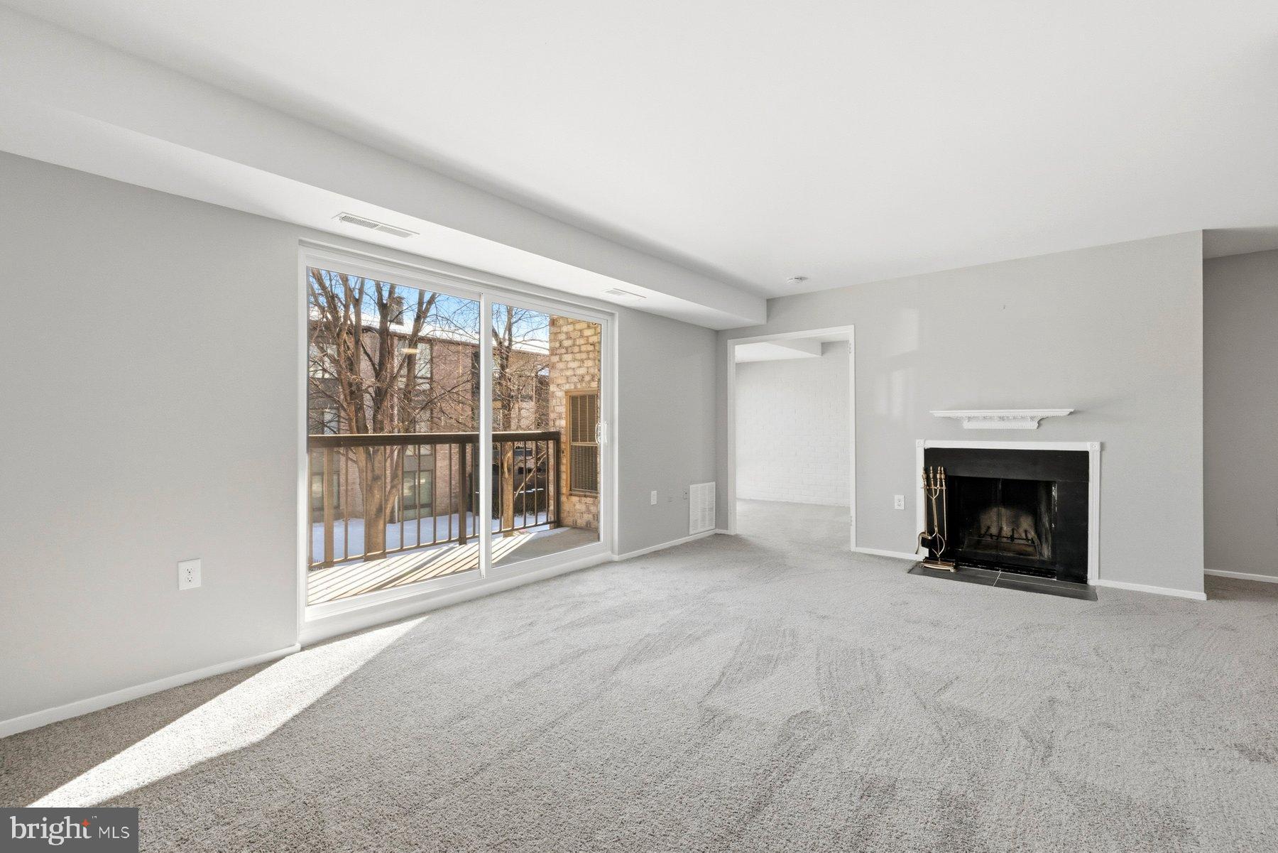 10026 Stedwick Road, Unit 201 Gaithersburg, MD 20886 - Photo 8 of 25 Bright and airy living space with balcony access.