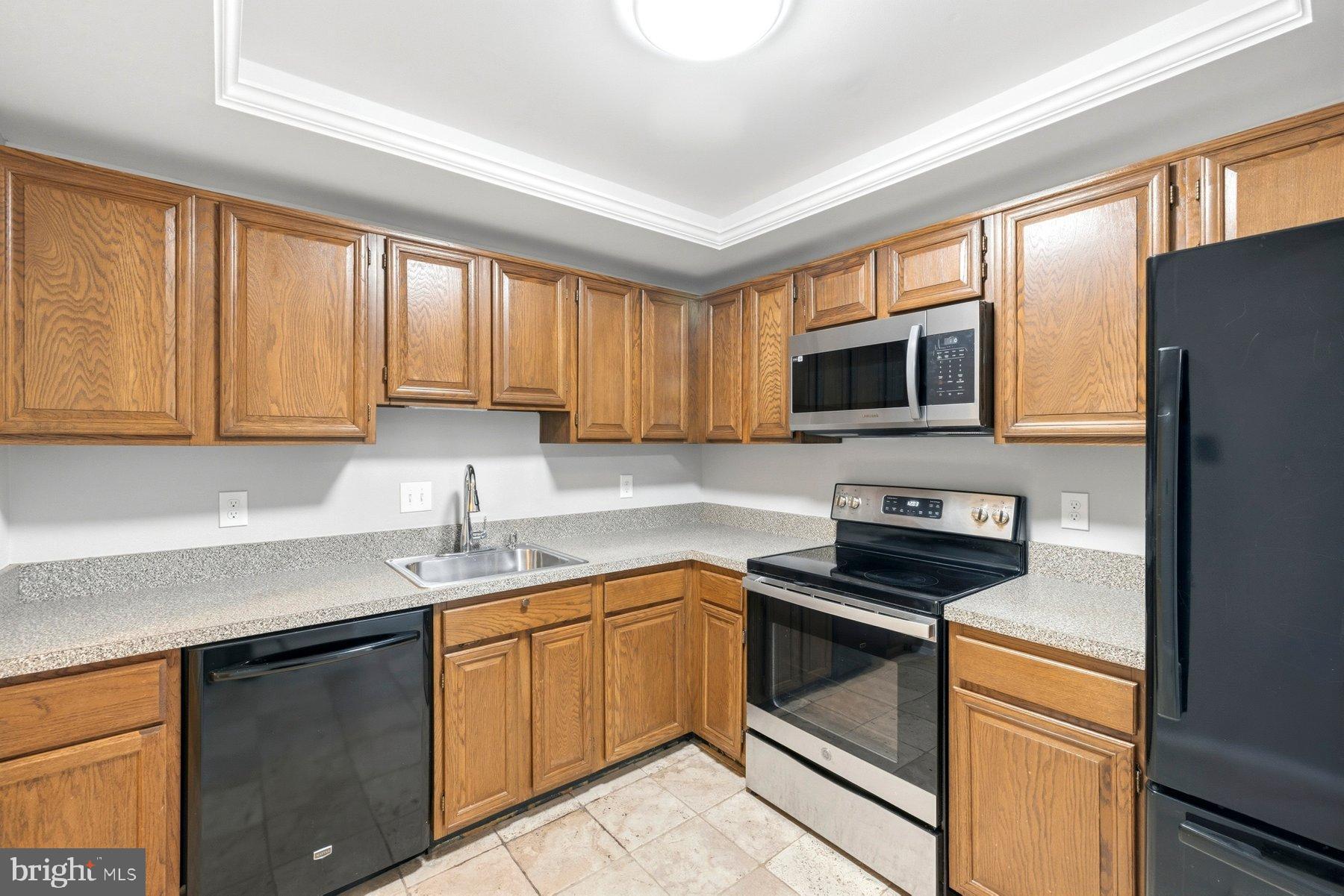 10026 Stedwick Road, Unit 201 Gaithersburg, MD 20886 - Photo 10 of 25 Modern kitchen with warm wood cabinetry.