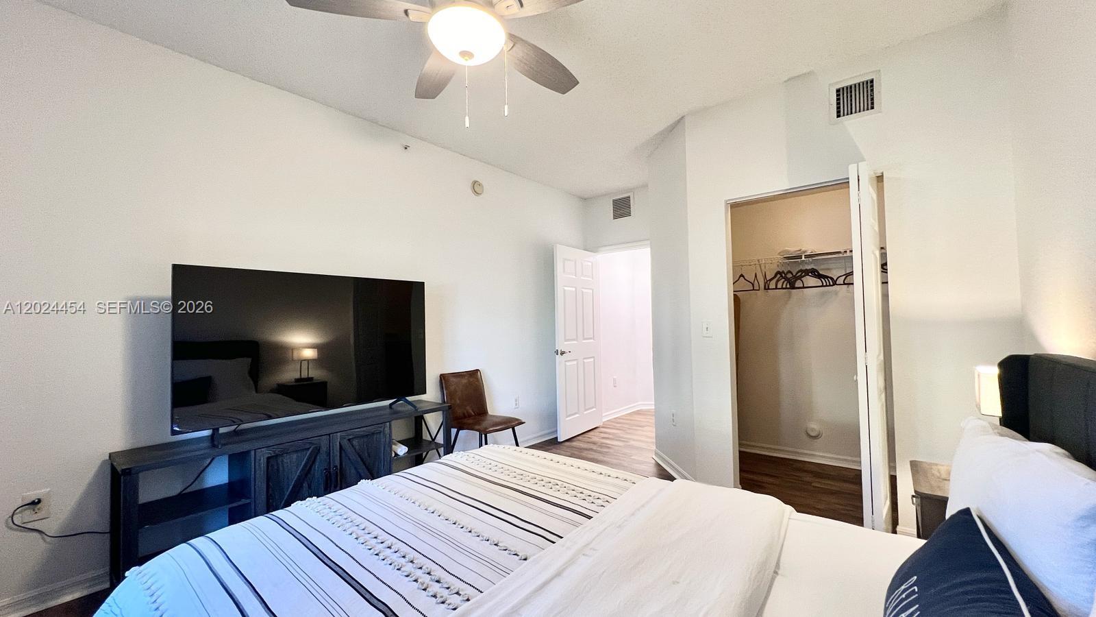 2727 Anzio Court, Unit 106 Palm Beach Gardens, FL 33410 - Photo 16 of 43 a bedroom with a bed and a flat screen tv