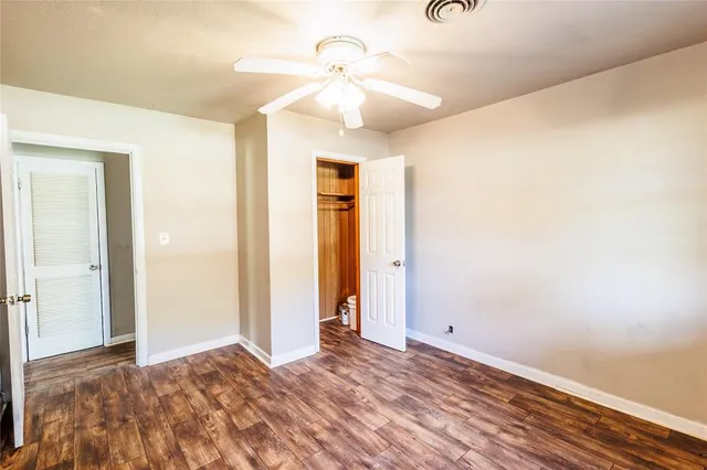 a view of a livingroom with wooden floor and a ceiling fan