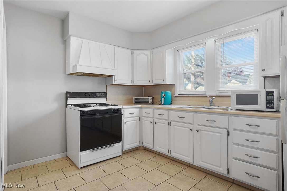 3206 9th Street Northwest Canton, OH 44708 - Photo 26 of 32 Kitchen with white appliances, white cabinetry, and sink