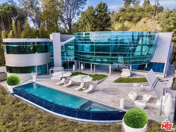 a view of a house with swimming pool and sitting area