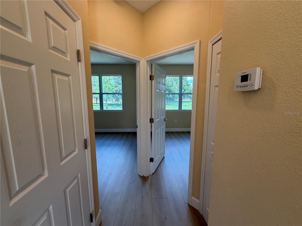 4661 Hickory Tree Road St. Cloud, FL 34772 - Photo 11 of 20 a view of a hallway with wooden floor and a bathroom