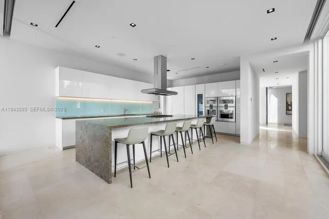 a kitchen with stainless steel appliances kitchen island granite countertop a table and chairs in it