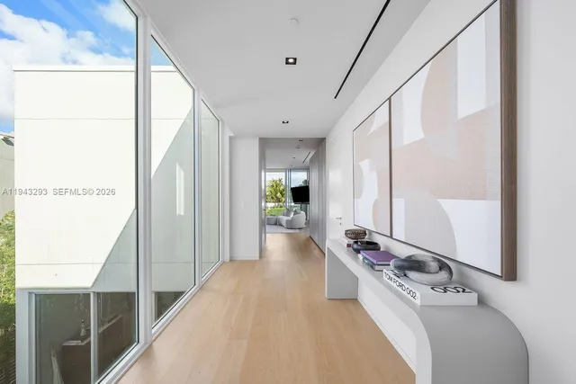 a view of a hallway with furniture and floor to ceiling window