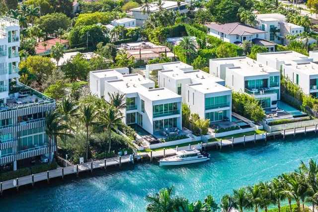 an aerial view of a house with swimming pool a yard and lake view