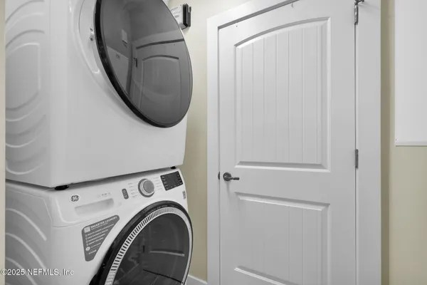 a bedroom with a bed lamp and a large window