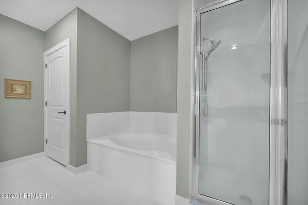 a bathroom with a tub sink and mirror