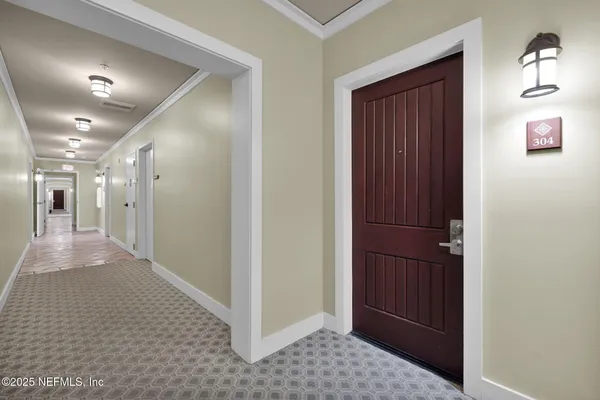 a view of a hallway with wooden floor and windows