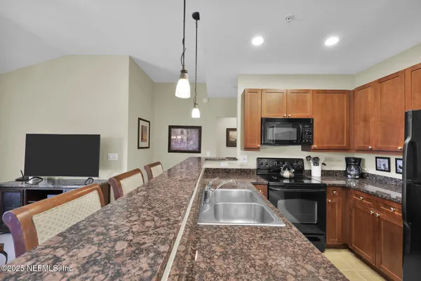 a kitchen with stainless steel appliances granite countertop a sink a stove and a refrigerator