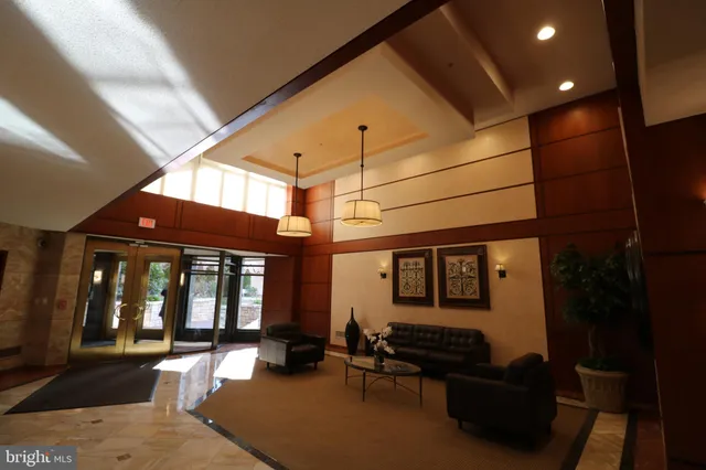 a living room with furniture a large window and potted plant