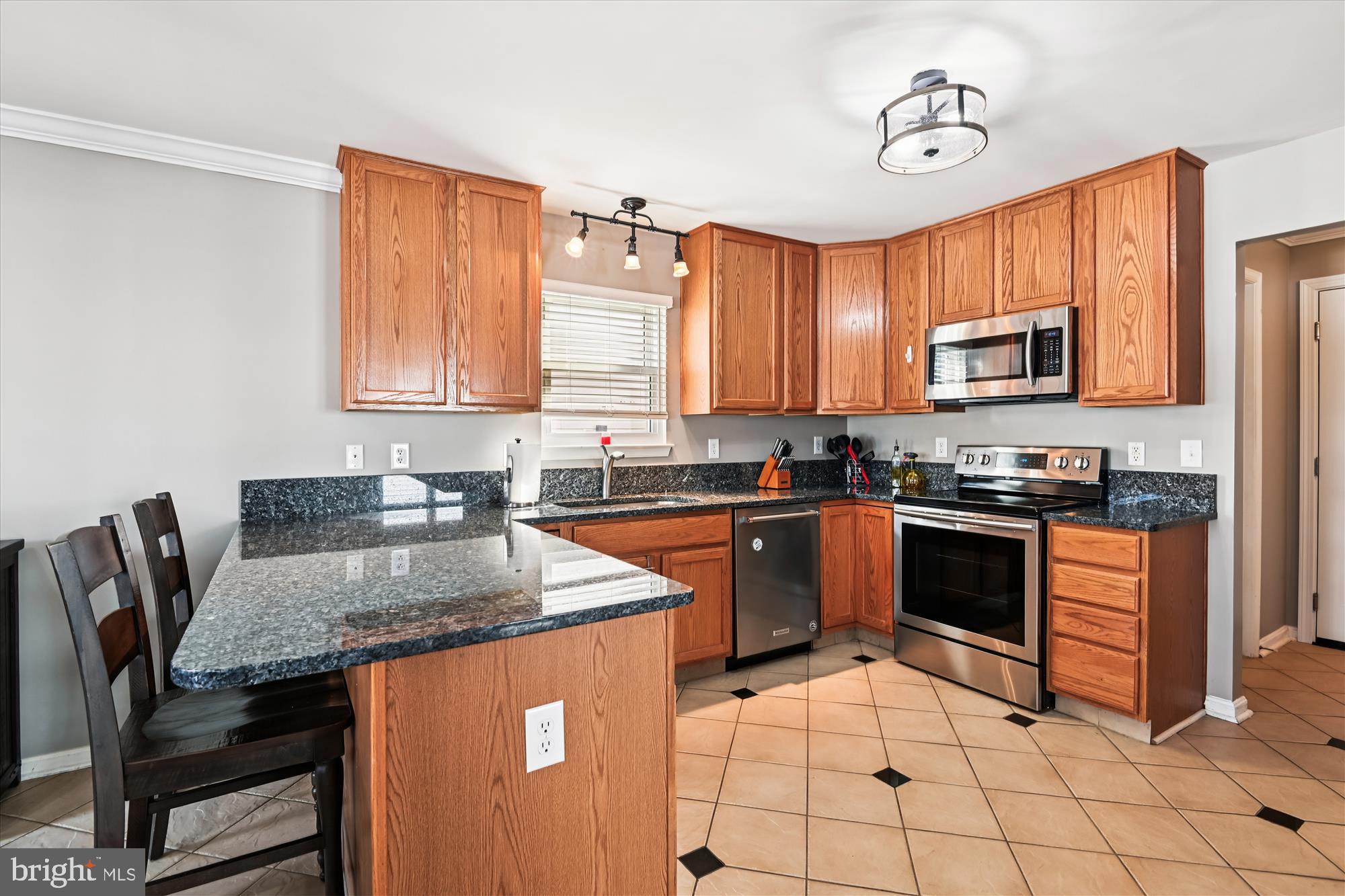 2310 228th Street Pasadena, MD 21122 - Photo 9 of 45 a kitchen with granite countertop a stove top oven a sink a counter top space and cabinets