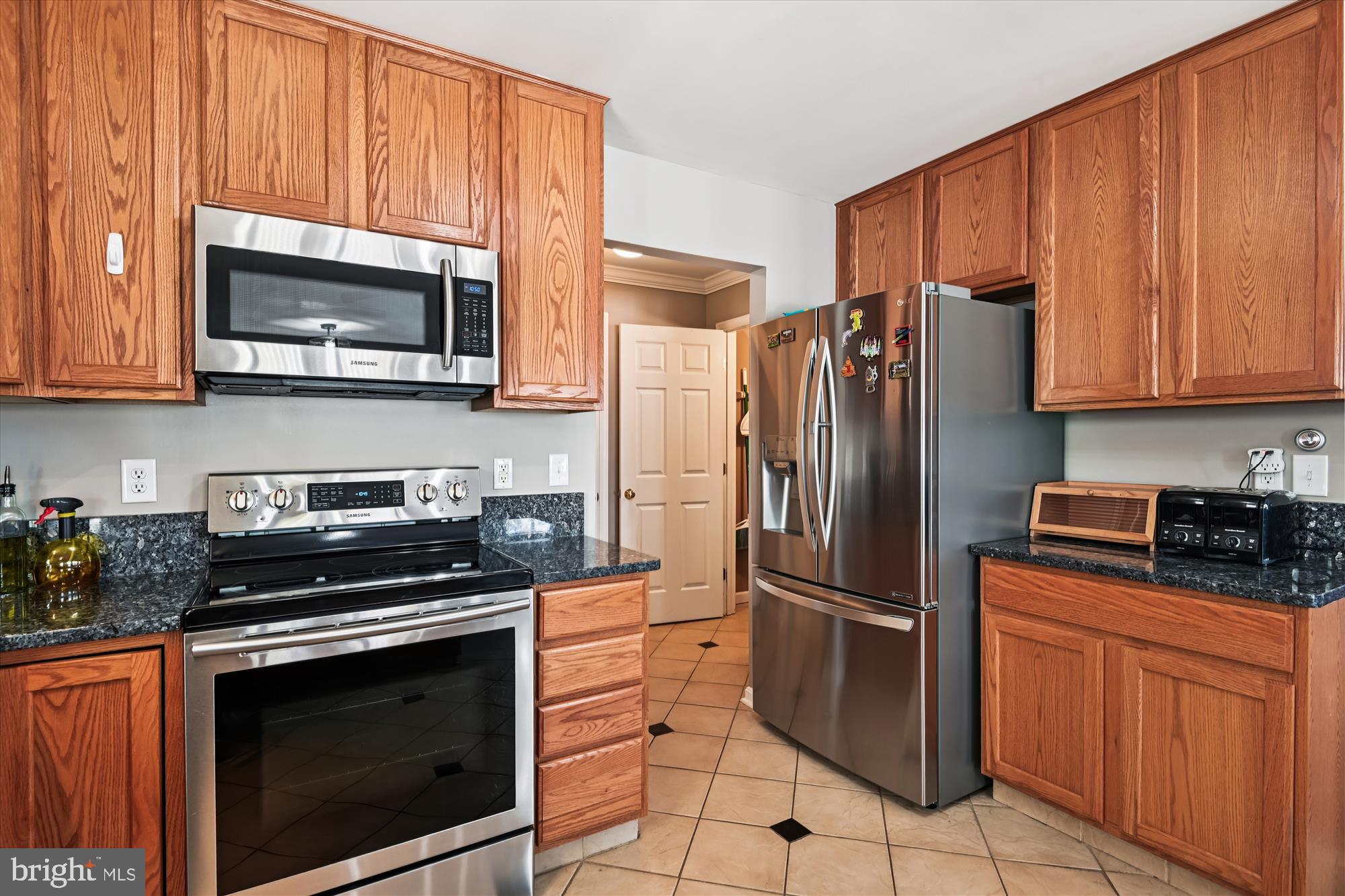 2310 228th Street Pasadena, MD 21122 - Photo 10 of 45 a kitchen with granite countertop a refrigerator stove and microwave
