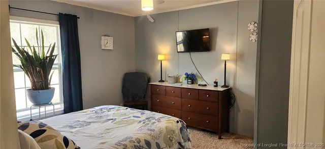 a bedroom with a bed and flat tv screen