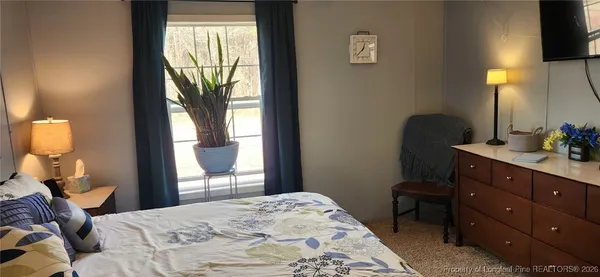 a bedroom with a bed and a dresser next to a window
