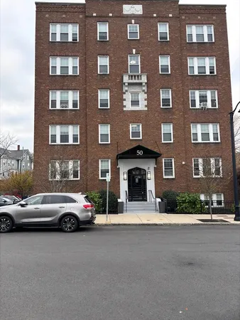 a view of building with cars parked across